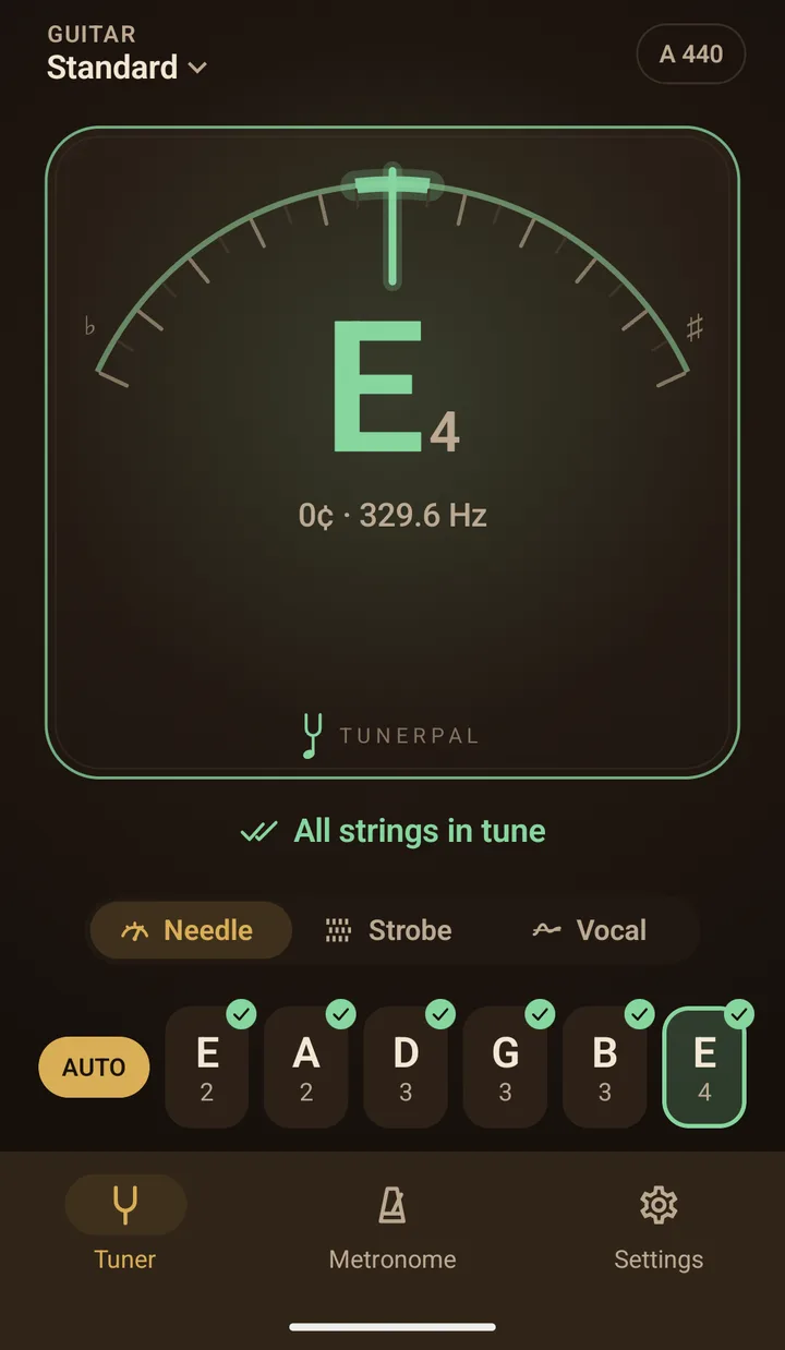 TunerPal's Tuner tab in the Classic theme: Guitar, Standard, A 440 at the top, the needle upright over a large green E4 reading 0 cents and 329.6 Hz on a raised faceplate whose rim glows green, with the TunerPal mark at its foot, All strings in tune, the Needle, Strobe and Vocal switch, and AUTO beside six string tiles, each with a tick
